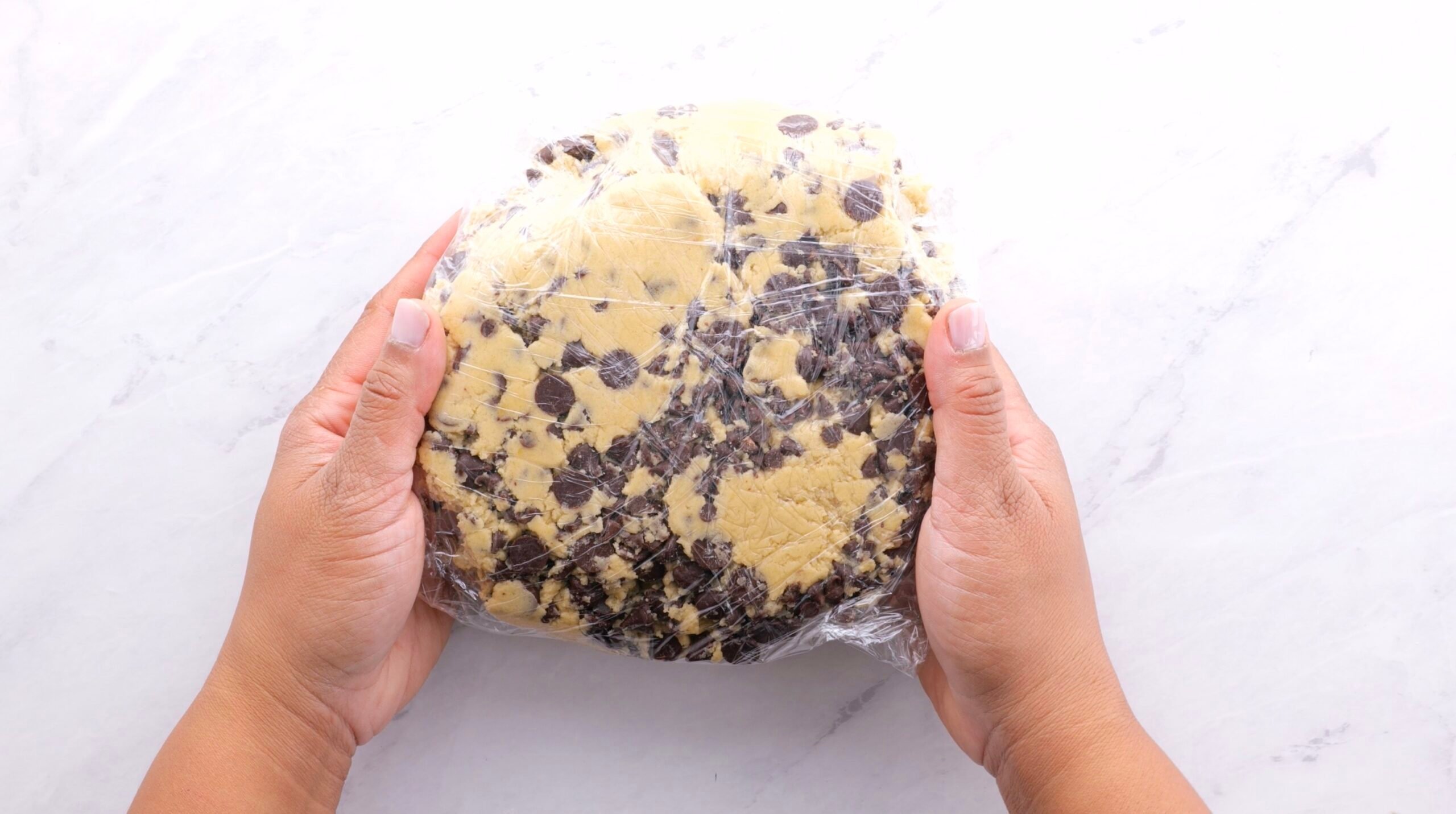 Bakery Style Chocolate Chip cookie dough wrapped in plastic wrap to chill