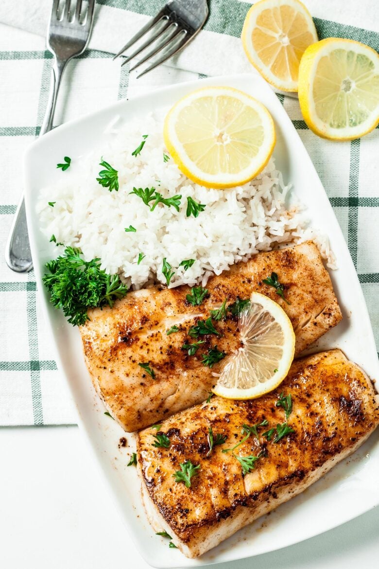 Fish in Lemon Butter Sauce in a plate with lemon slices