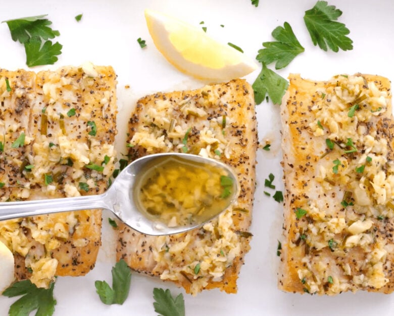 Topping the Mahi Mahi with the hot lemon garlic butter sauce.