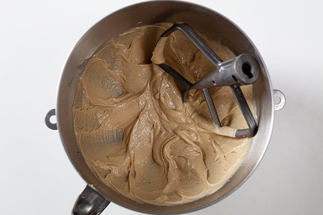 cookie dough batter in a large mixing bowl with a paddle attachment