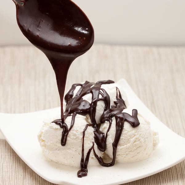 hot fudge sauce being drizzled over vanilla ice cream