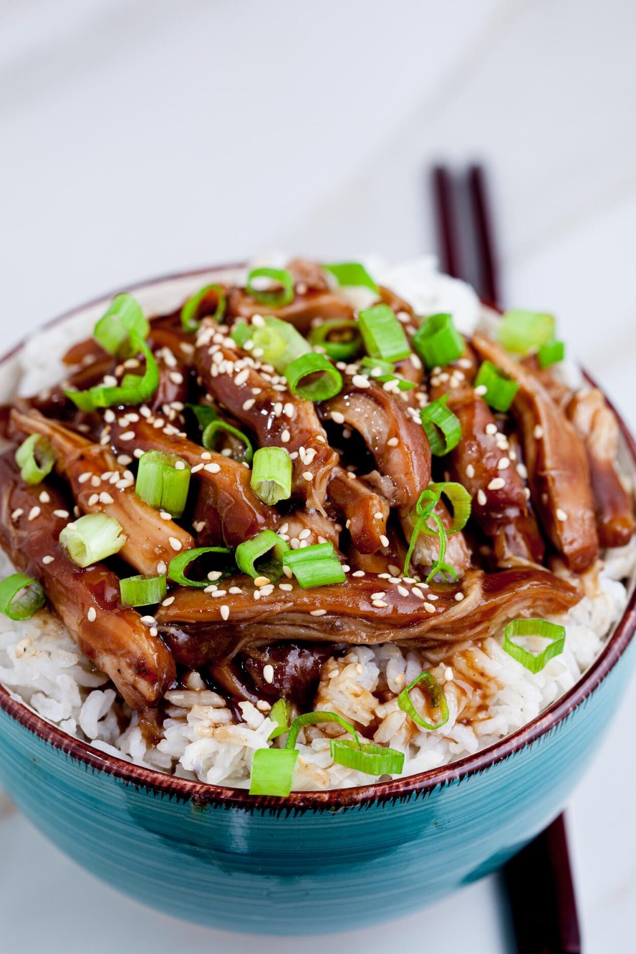 Slow Cooker Teriyaki Chicken over rice in a bowl.
