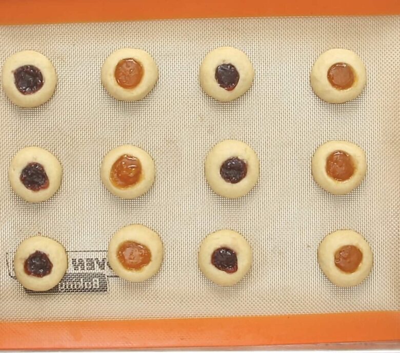 Jam thumbprint cookies baked on tray.