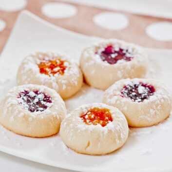 jam thumbprint cookies on a white plate.