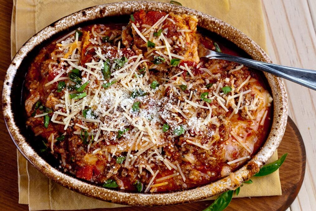 Baked ravioli casserole in oval dish horizontal shot