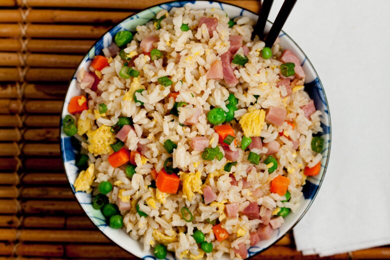 overhead image of a bowl of ham fried rice with egg and vegetables