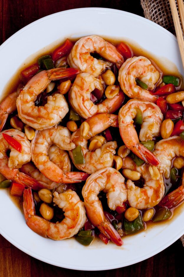 Kung Pao Shrimp in a white plate with chopsticks