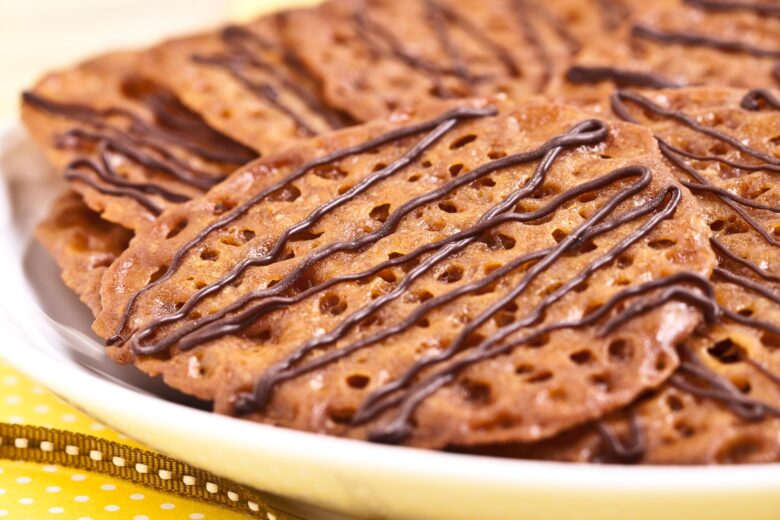 a plate of orange lace cookies drizzled with chocolate