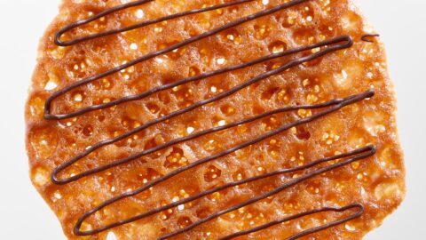 an orange lace cookie drizzled with chocolate