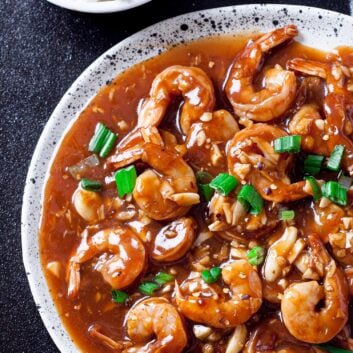 Shrimp stir fry on a plate with a bowl of rice