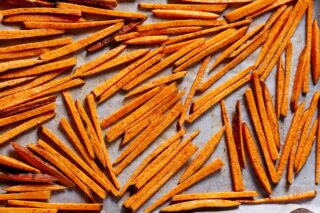 sweet potato fries on a parchment-lined baking sheet