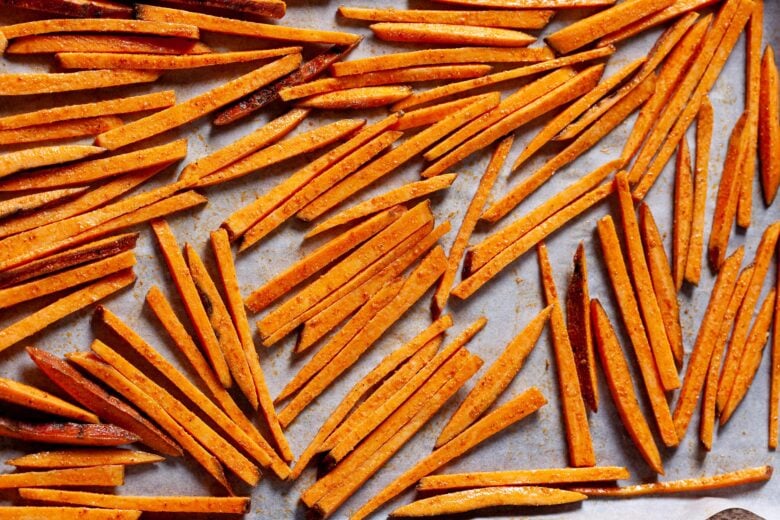 sweet potato fries on a parchment-lined baking sheet