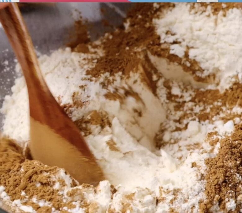Flour, baking powder, cinnamon, nutmeg ingredients in bowl.