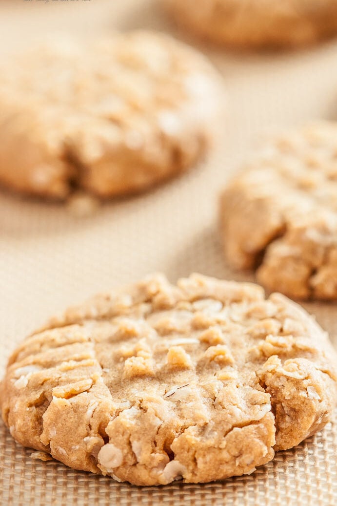 close up image of peanut butter oatmeal cookies on parchment paper