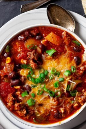 instant pot chili with a tortilla chip sticking out and a spoon on the side