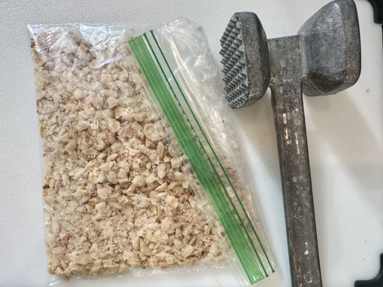 peanuts being crushed in a bag and meat tenderizer
