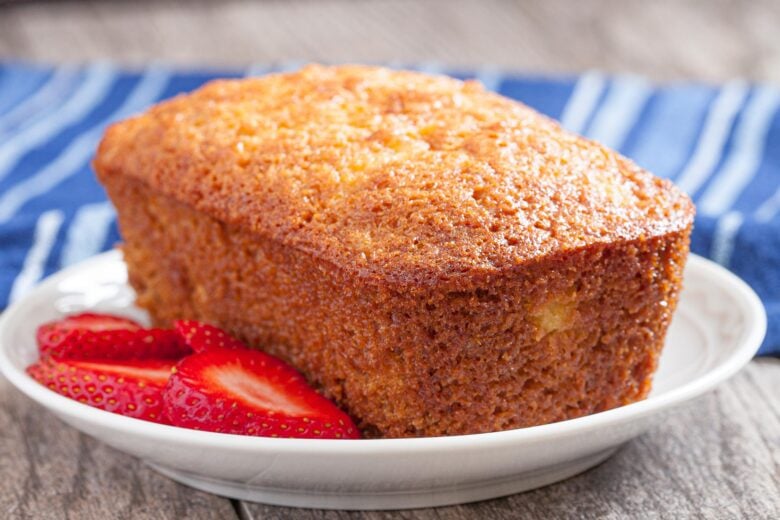 Pineapple cake loaf on a white plate with strawberries