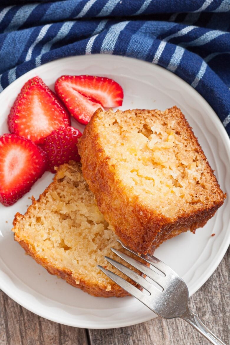 Sliced Pineapple Cake with strawberries on the side.