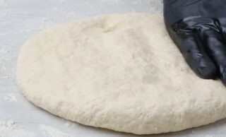 Buttermilk biscuit dough rolled out on the table.