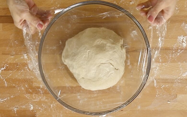 Cover the dough with saran wrap to rise.