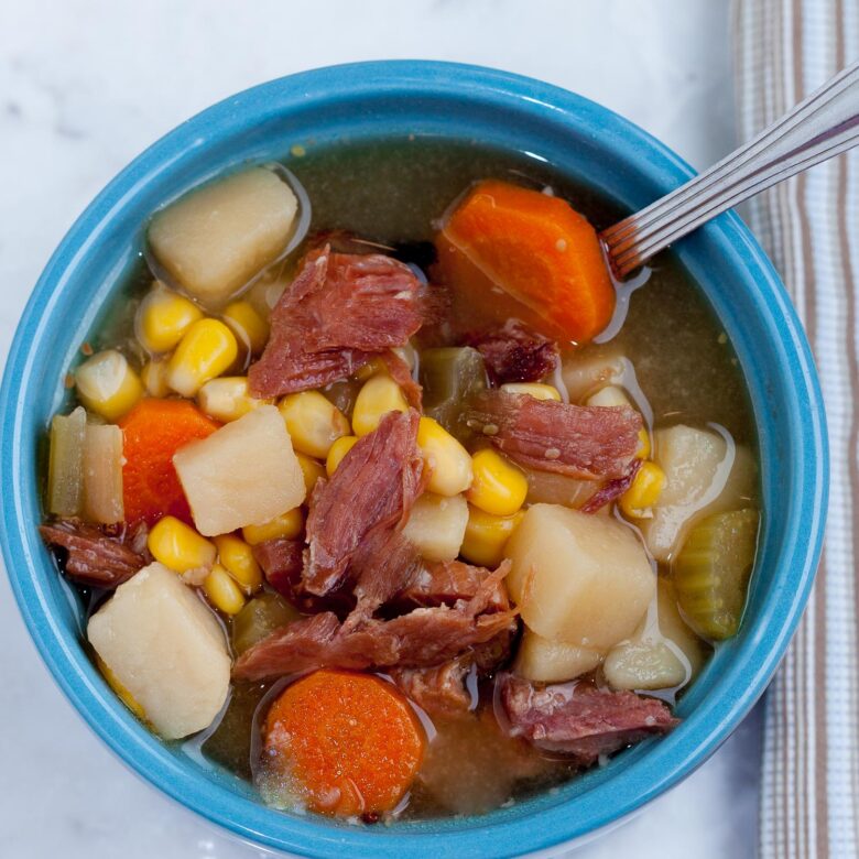 Ham bone soup with chopped ham, potatoes, and carrots in a bowl