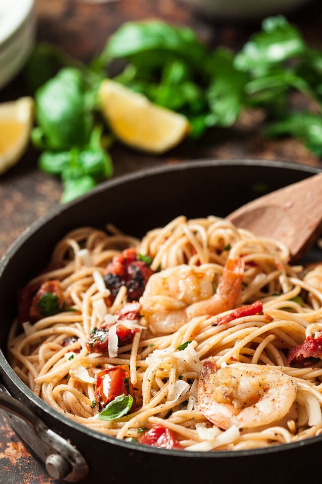 Shrimp Scampi and pasta in a skillet, with shrimp and basil and tomatoes