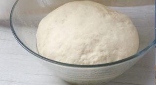 Sourdough sandwich bread rising in a lightly greased bowl.