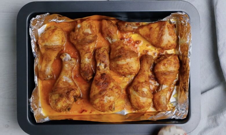 Tandoori chicken partially baked before going back into the oven to broil.