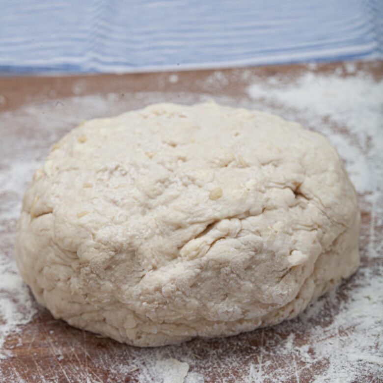 Fully mixed buttermilk biscuit dough formed into a ball on the table.