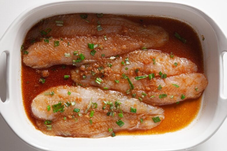 Swai fish fillets with sauce in baking dish for Chinese steamed fish