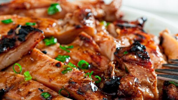 Grilled Chicken Thighs with Asian Marinade Sliced on white plate