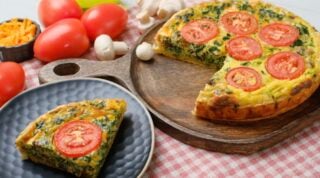 Baked quiche sliced and placed on a plate.