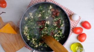 Quiche filling ingredient sautéing in a pan.