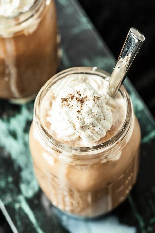 thai iced coffee recipe in a mug with whipped cream 