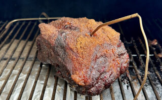 smoked pork butt on the smoker with meat thermometer