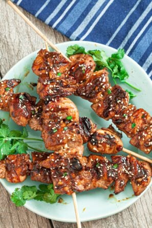 Asian chicken skewers on a plate
