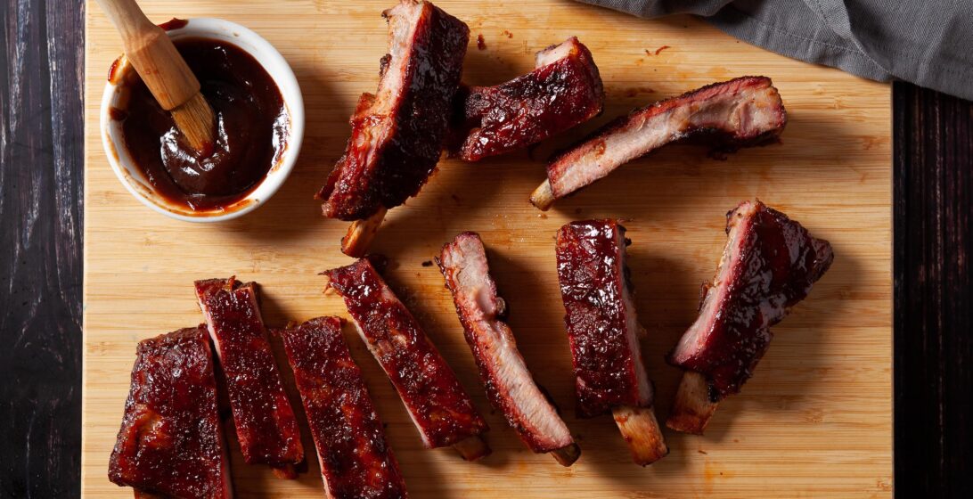 smoked ribs on a platter with sauce