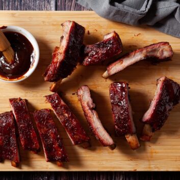 smoked ribs on a platter with sauce