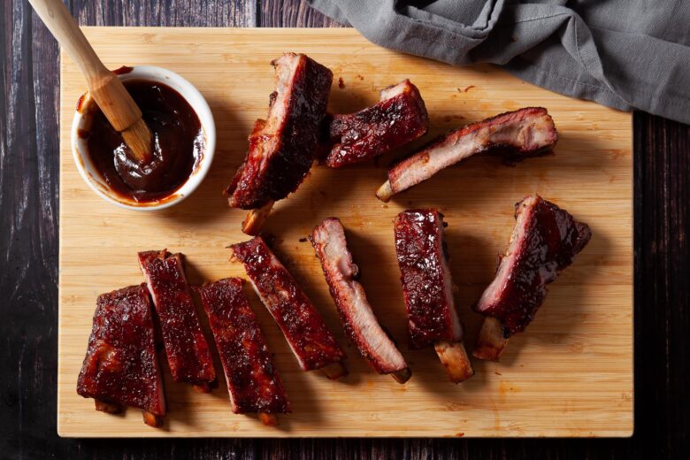 smoked ribs on a platter with sauce