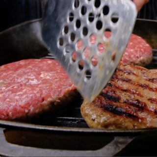 Ground beef patties cooking on a grill or pan