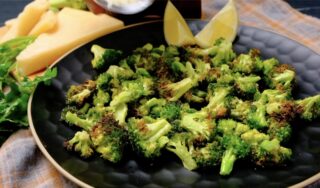 air fryer broccoli on a plate with lemons and parmesan