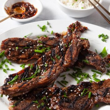 Kalbi beef short ribs on a white plate with rice and sauce