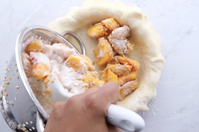 Peach filling going into pie crust