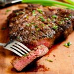 Grilled ribeye or t-bone steak on a cutting board