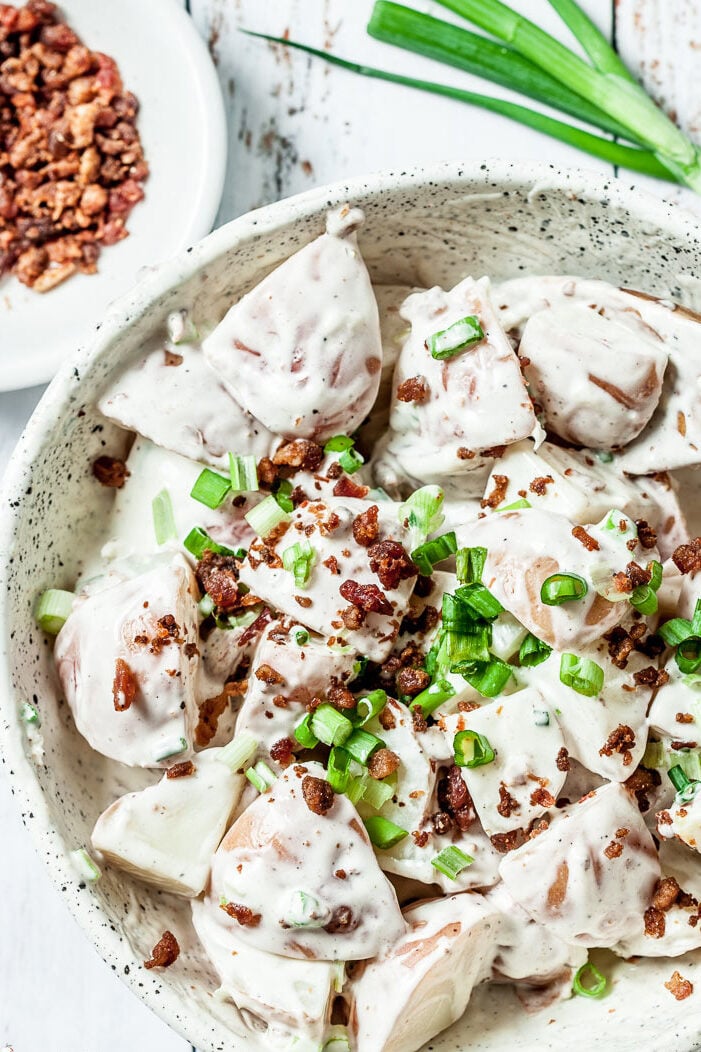 ranch potato salad in a bowl with onions and bacon