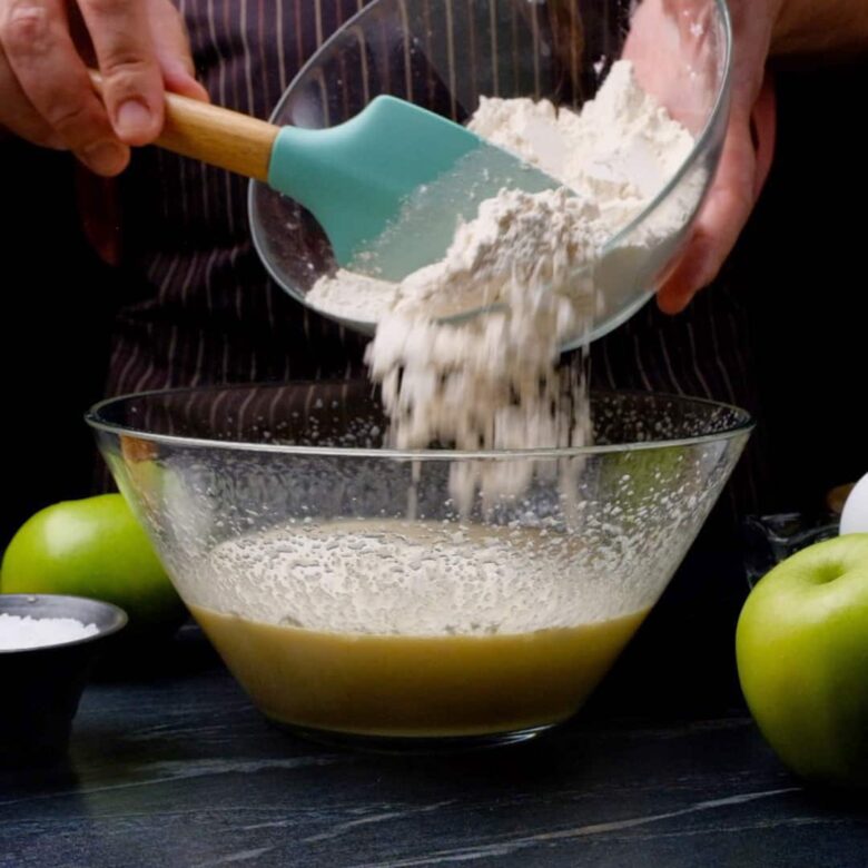 Folding dry ingredients into wet ingredients for apple cake