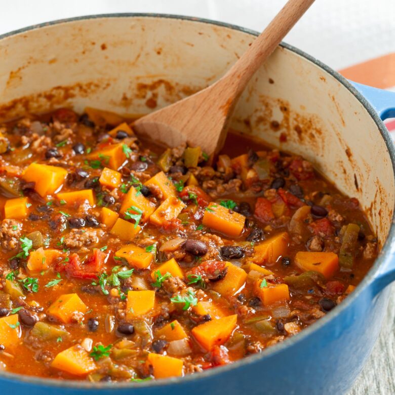 butternut squash chili in a blue pot with ladle