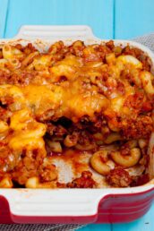 Chili Mac being served from a red baking dish.