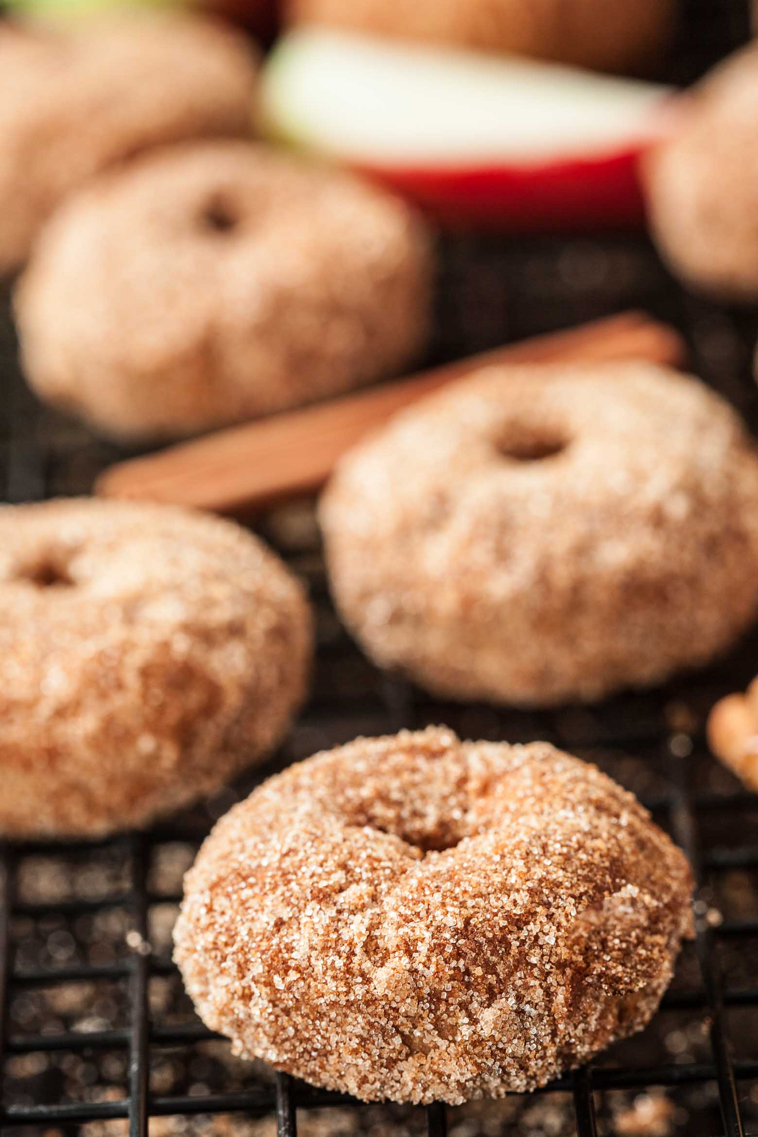 Close up of a cinnamon apple baked donut with more blurred out in the background.
