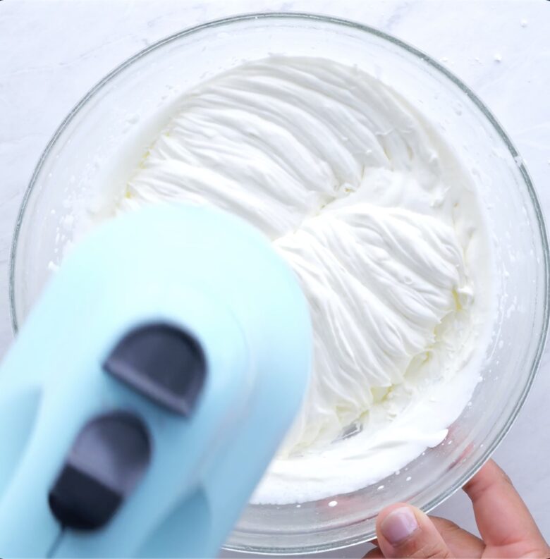 stabilized whipped cream in a bowl being whipped.